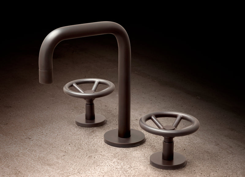 Aged brass kitchen faucet by Watermark Designs on a marble counter, its living finish beginning to deepen with use
