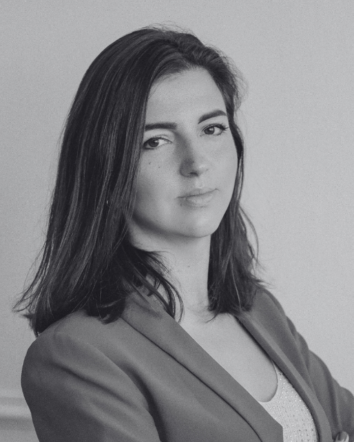 Black and white portrait of a woman with a neutral expression against a plain background