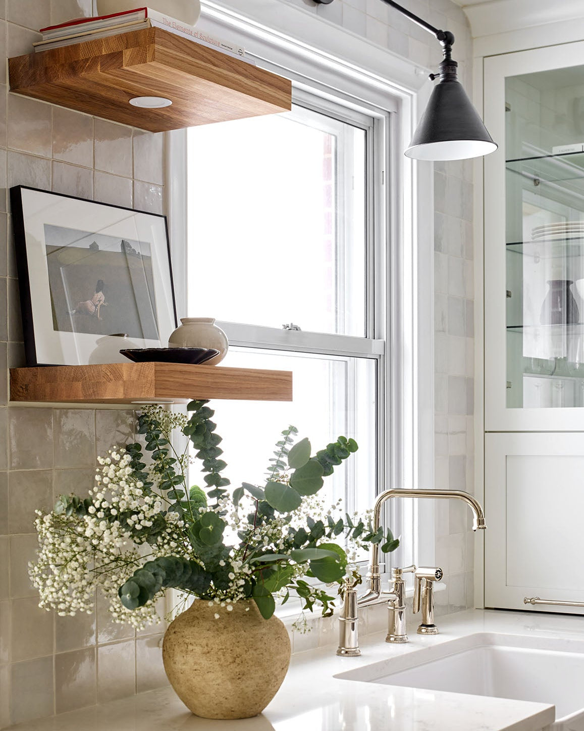 Modern kitchen with wooden shelves, window, and sink area.
