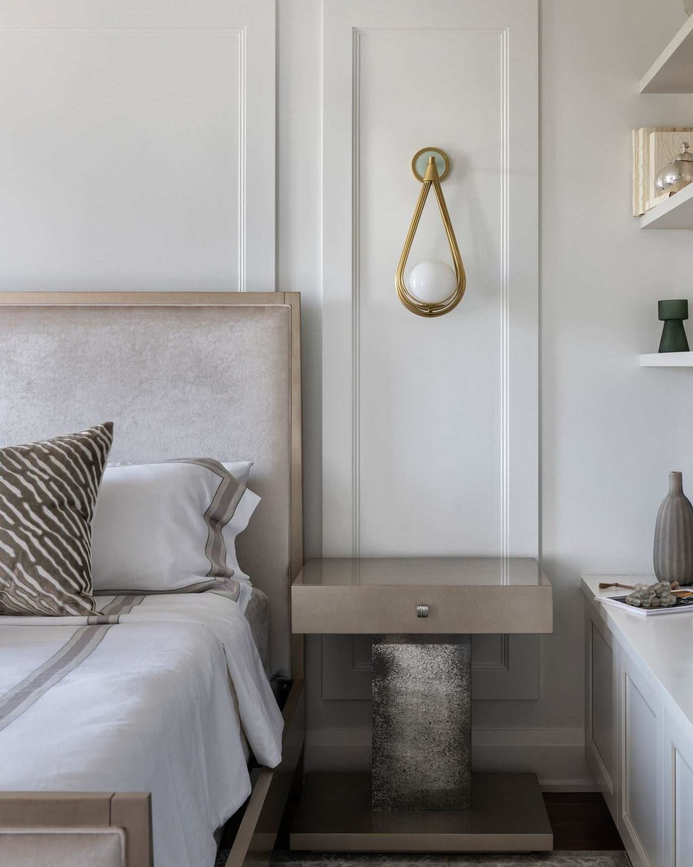 Modern bedroom with a bed, nightstand, and decorative elements.