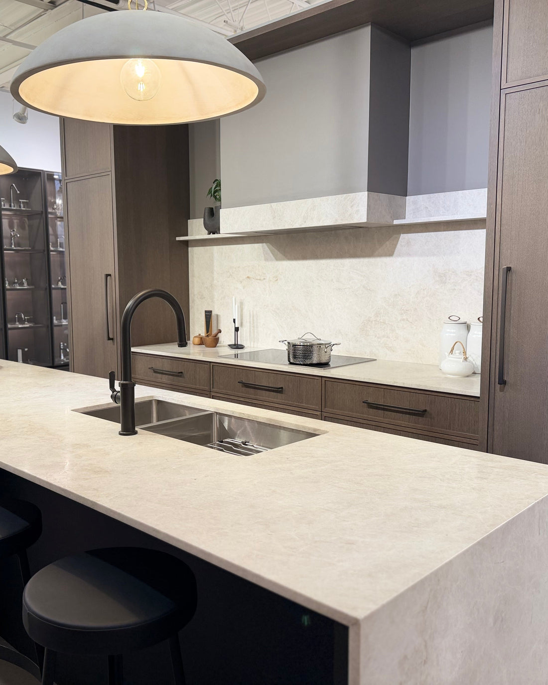 Modern kitchen with marble countertop, sink, and cabinets.