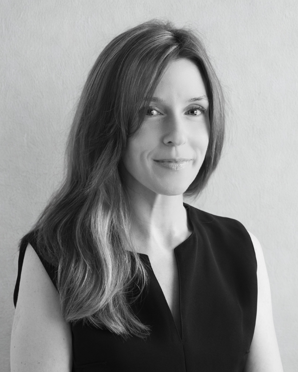 Black and white portrait of a woman with long hair against a plain background