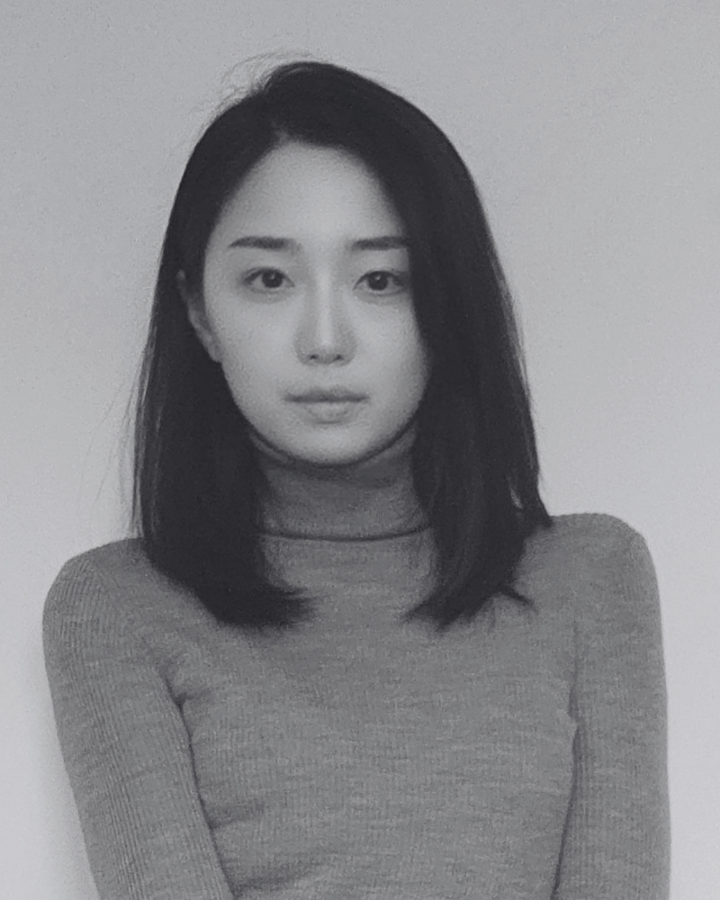 Black and white portrait of a person wearing a turtleneck sweater against a plain background